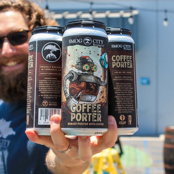 man with a beard holding a 4-pack of coffee porter cans outside