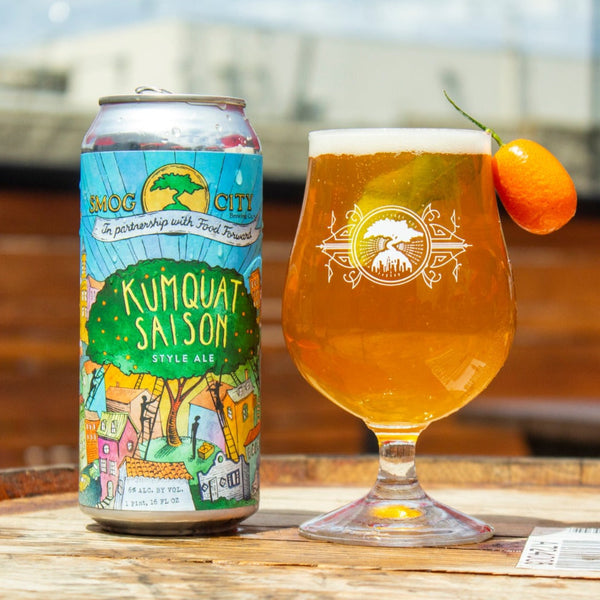 can of kumquat saison next to a glass of the beer in a tulip glass with kumquat fruit garnish on the rim