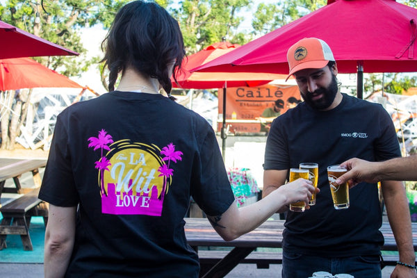 Two people wearing From LA Wit Love T-Shirts and cheersing with some beers