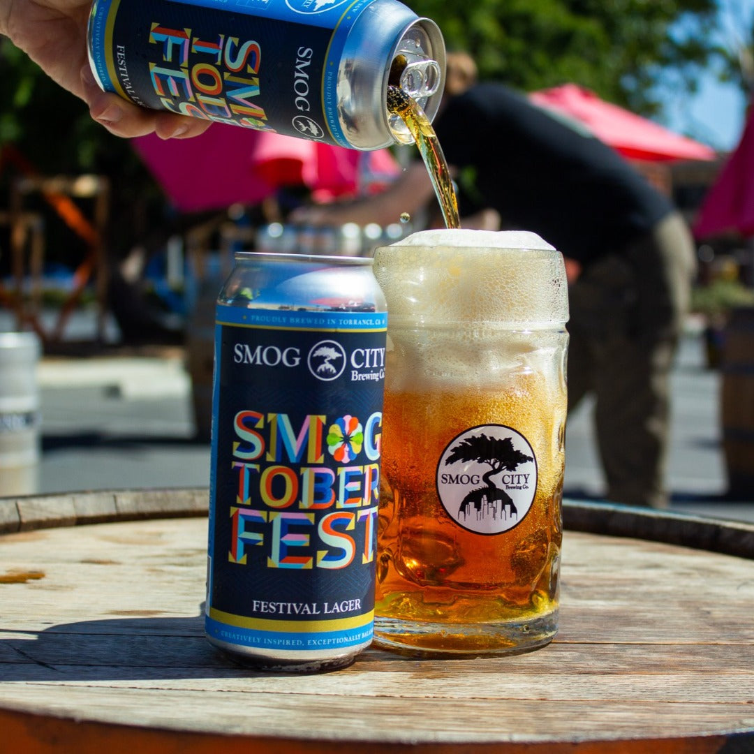 blue smogtoberfest can next to a smog city beer stein with beer being poured in